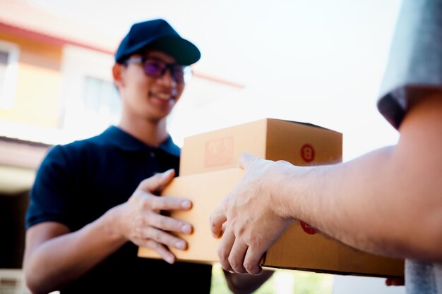 Photo smiling delivery man handing boxes to customer