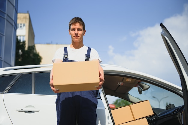 Smiling delivery man holding a paper box