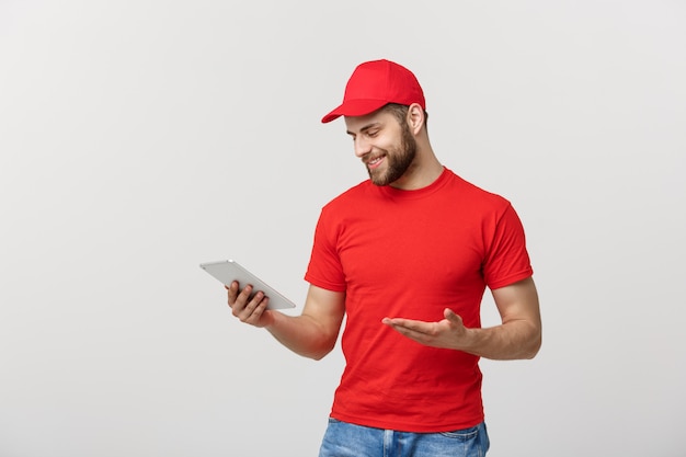 Smiling delivery man with tablet in studio.