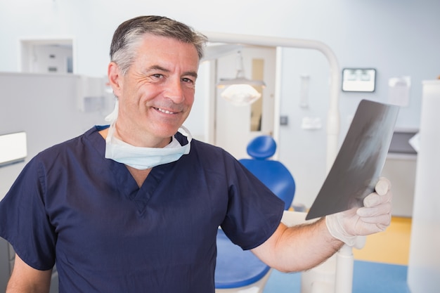 Smiling dentist examining a x-ray 