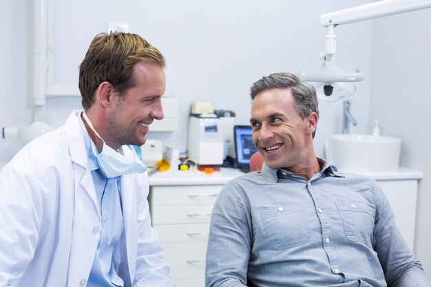 Smiling dentist and patient interacting with each other