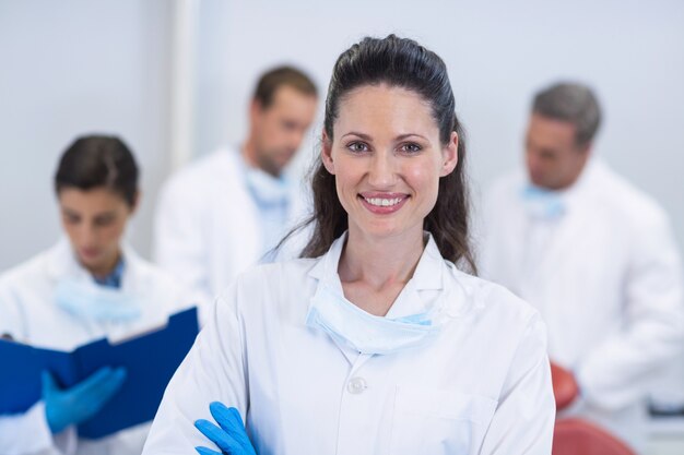 Smiling dentist standing with arms crossed