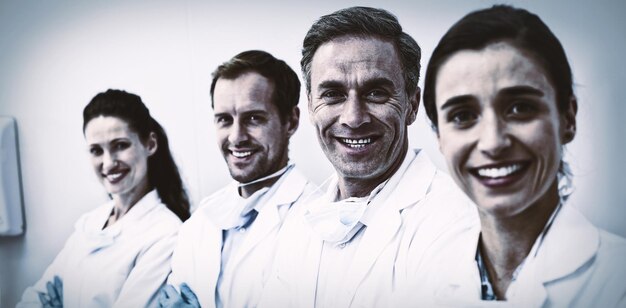 Photo smiling dentists standing with arms crossed