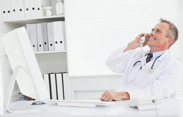 Photo smiling doctor answering a call