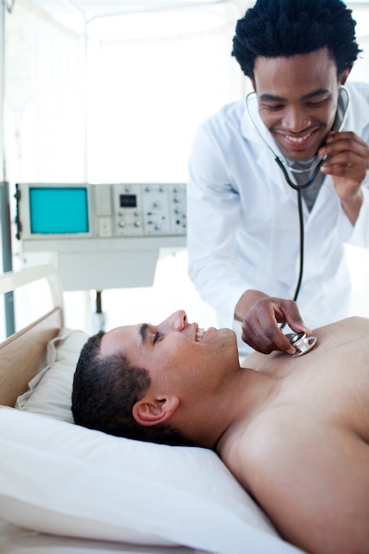 Smiling doctor checking the pulse on a male patient