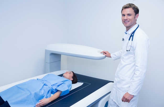 Smiling doctor doing a radiography on a patient