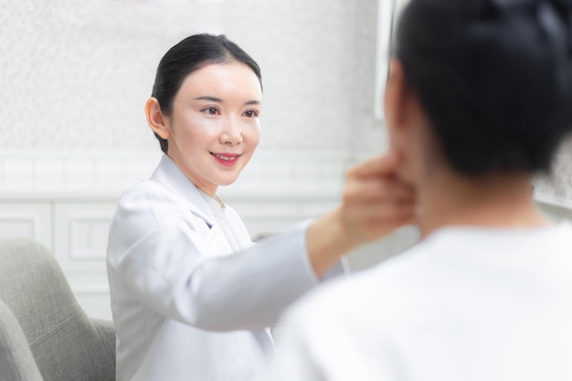 Smiling doctor examining patient at beauty spa