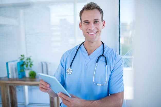 Smiling doctor holding his tablet