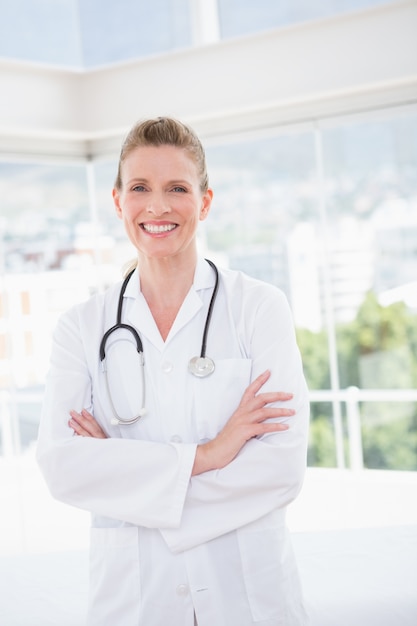 Smiling doctor looking at camera with arms crossed 