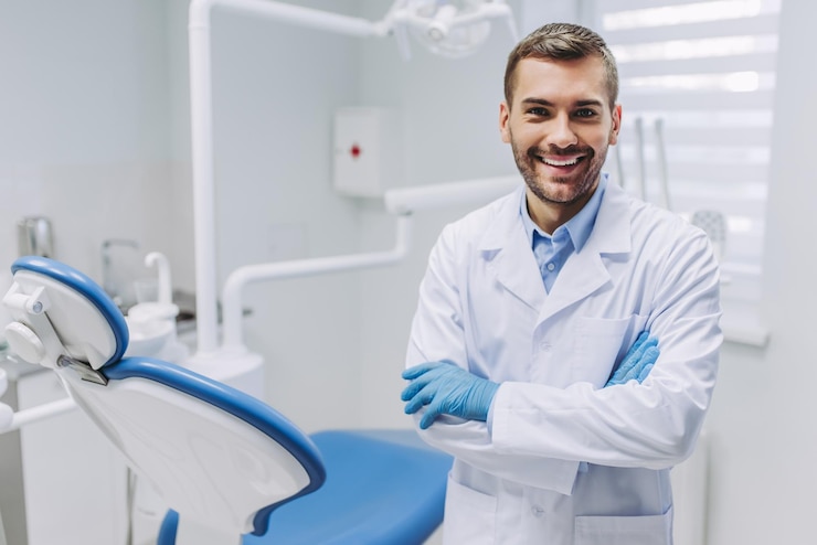 Photo smiling doctor in medical gloves with crossed hands looking at the camera in dental clinic