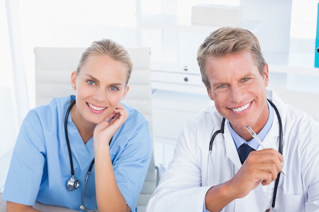 Smiling doctor and nurse looking at camera 