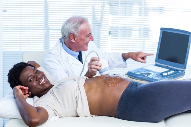 Smiling doctor showing movements of baby on screen 