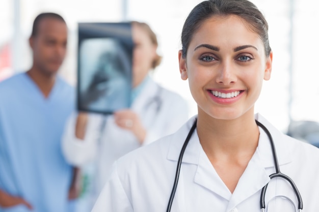 Smiling doctor standing in a bright hospital