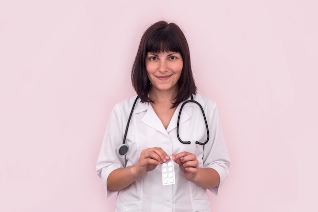 Smiling doctor taking out tablet from blister