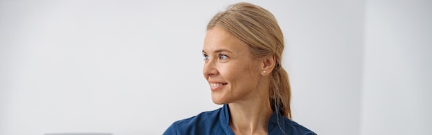 Smiling doctor ultrasound specialist looking at side on her workplace in clinic