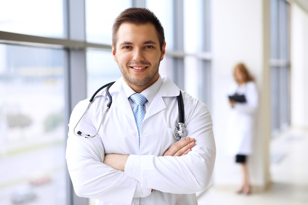 Smiling doctor waiting for his team while standing upright