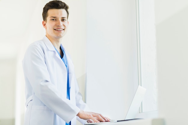 Smiling doctor with laptop