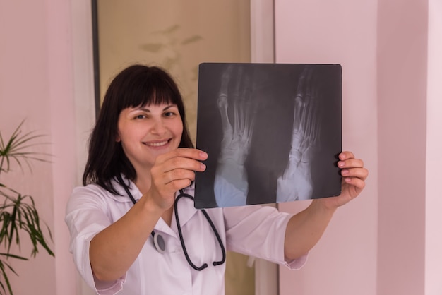 Smiling doctor with patient's x-ray in hands