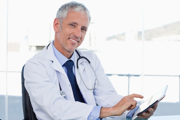 Photo smiling doctor working with a tablet computer