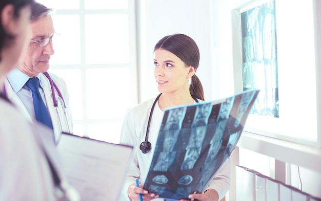 Smiling doctors discussing patient's diagnosis looking at xrays in a hospital