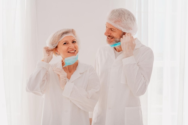 Smiling doctors with face mask are happy to work against covid19