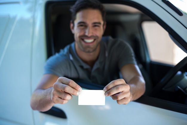 Smiling driver man showing blank card