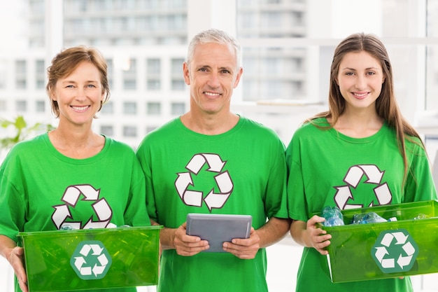 Smiling eco-minded colleagues with recycling boxes