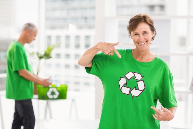 Smiling eco-minded woman showing her recycling shirt