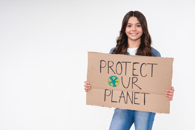 Smiling ecofriendly teenage girl holding a poster with save the planet concept isolated in white background