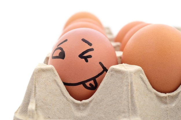 Photo smiling egg in a carton box, close up view.