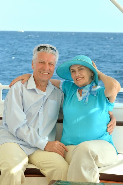 Smiling elderly couple resting on yacht