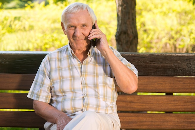 Улыбающийся пожилой мужчина с телефоном