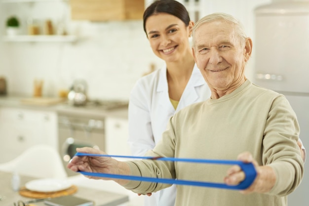 Smiling elderly man and young nurse looking at the camera