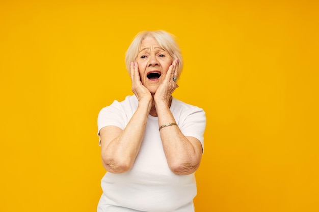 Smiling elderly woman in casual tshirt gestures with his hands closeup emotions