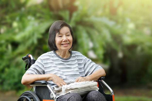 車椅子に座って、笑顔の年配の女性