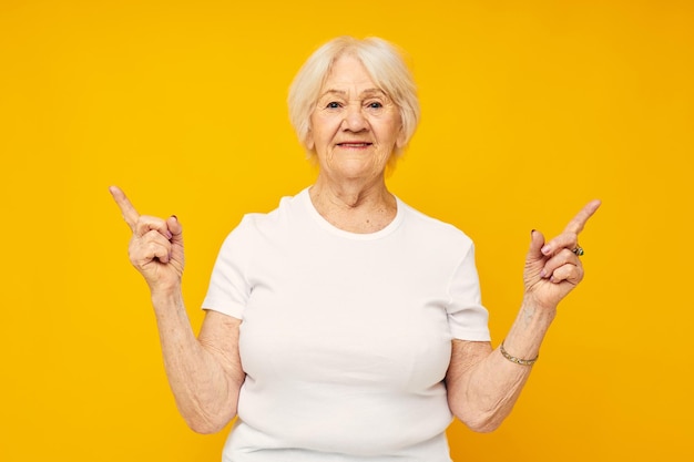 Smiling elderly woman in white tshirt posing fun isolated background