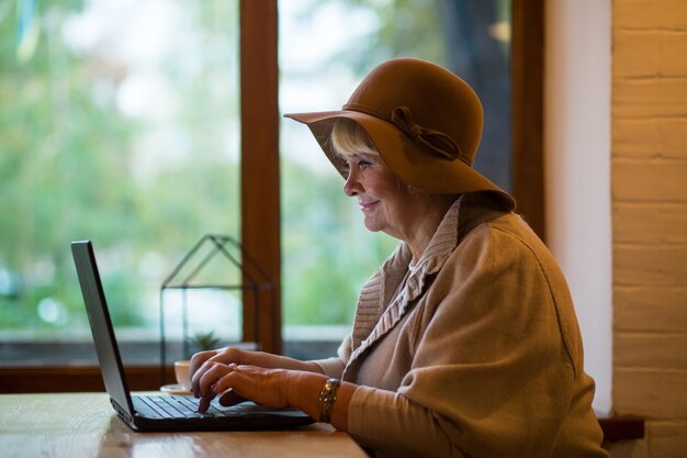 Smiling elderly woman with laptop