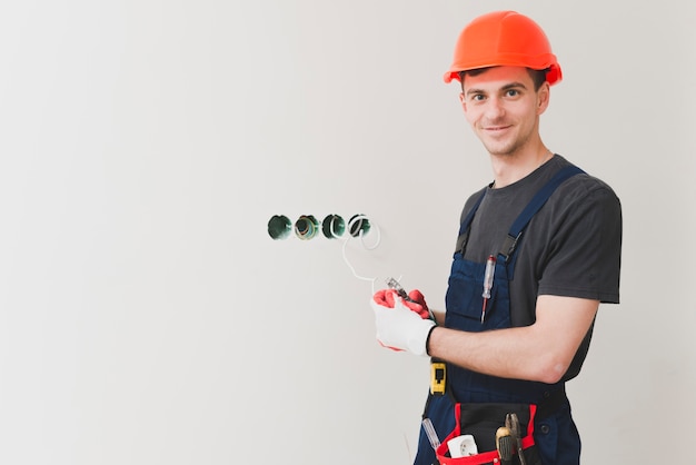 Foto elettricista sorridente ai fori di ostruzione