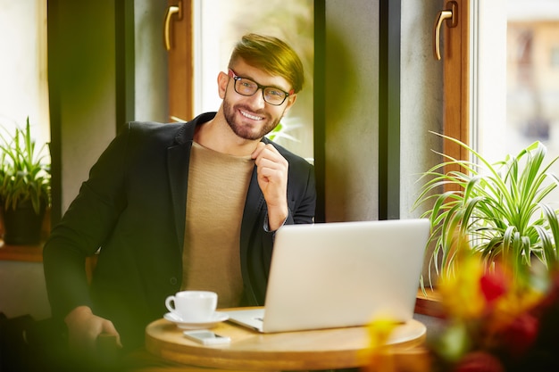 Foto sorridente uomo emotivo al laptop