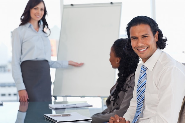 Smiling employee listening to the presentation given by a colleague