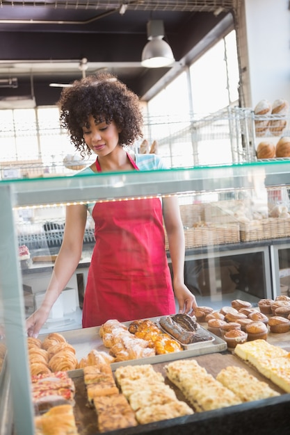 Smiling employee behind the pastry