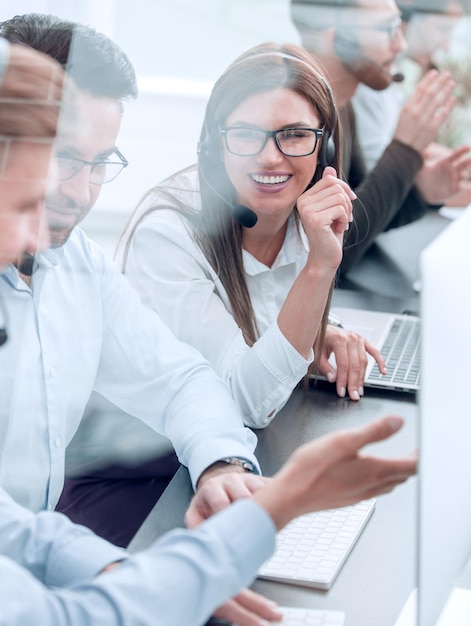 Smiling employees of call center talk sitting behind a Desk