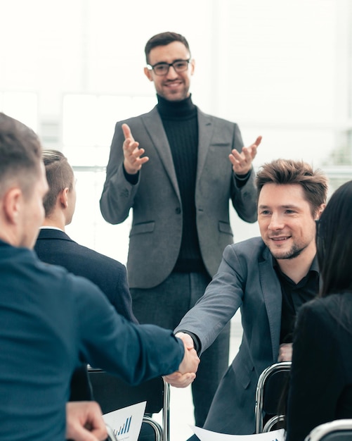 Smiling employees shaking hands during a working meeting