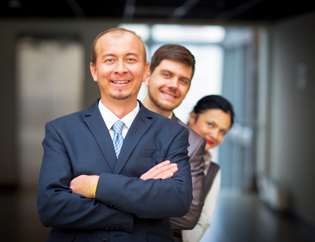 Smiling employees standing around their manager