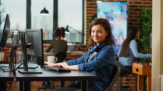 Smiling engineering specialist planning machinery component development on cad software. Happy woman working on 3d manufacturing interface for industry machine production in studio.