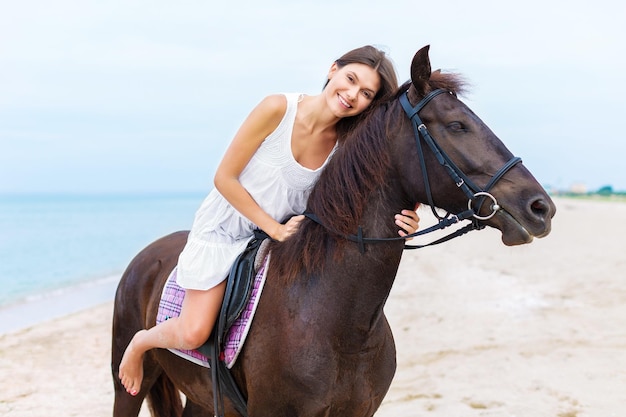 Улыбающаяся наездница верхом на лошади на пляже