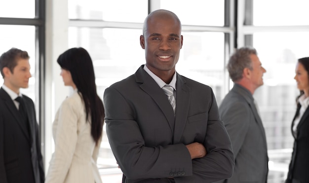 Smiling ethnic business leader in front of team 