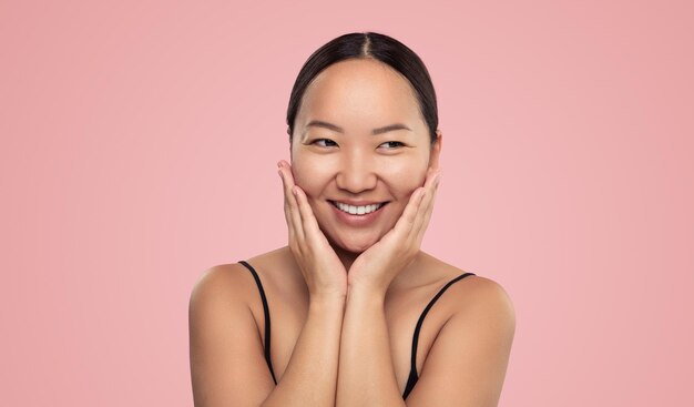 Smiling ethnic woman touching cheeks