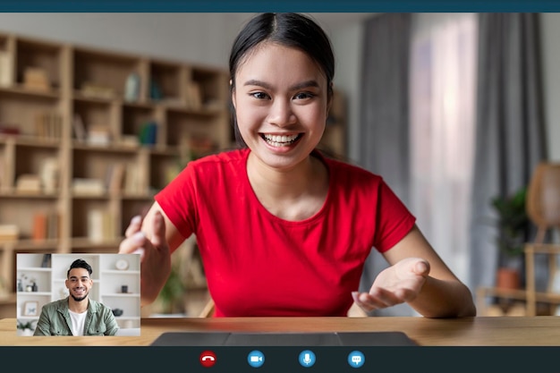 Foto sorridente eccitata studentessa coreana si rallegra guarda lo schermo del laptop ha una chiamata online con un insegnante arabo