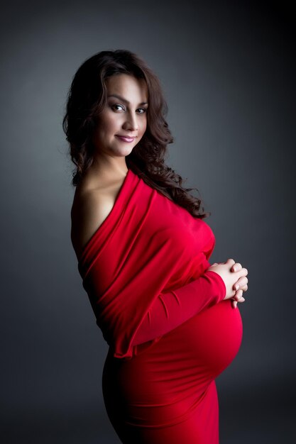 Photo smiling expectant mother posing at camera